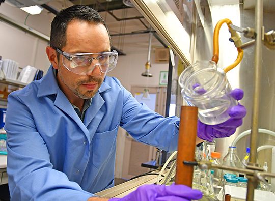Photo. Explosives chemist David Chavez pours a melt-castable explosive into a copper mold at the Laboratory’s Technical Area 9.