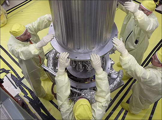 Photo. Los Alamos and NASA engineers lower the vacuum chamber over the Kilopower test reactor during testing at NCERC.